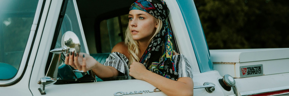 Young woman sitting in a truck, photo by Averie Woodard