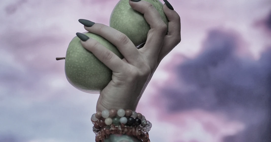 Hand grasping two pieces of fruit, photo by Moa Kiraly