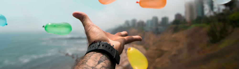 Hand throwing balloons, photo by Sebastián León Prado