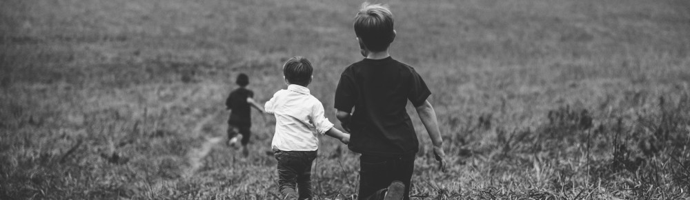 Boys running in a field, photo by Jordan Whitt