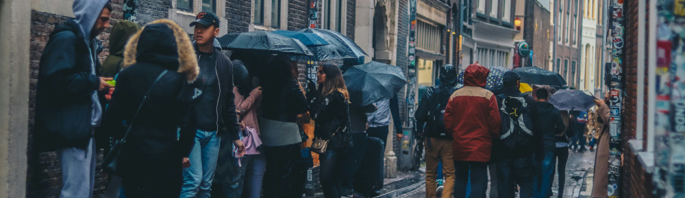 People waiting in line in the rain, photo by Ethan Hu